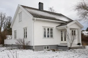 Fasade av trebolig i Nedenes med fokus på hjørnekasse og yttervegg